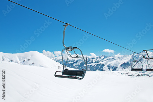 Ski lift chairs on bright winter day