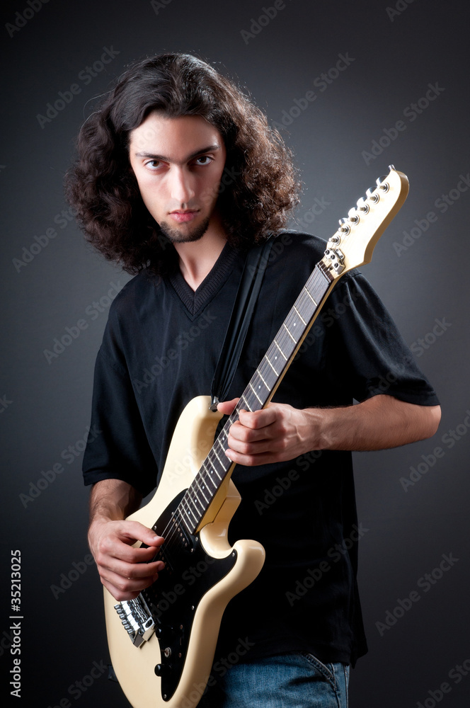 Obraz premium Guitar player against the dark background