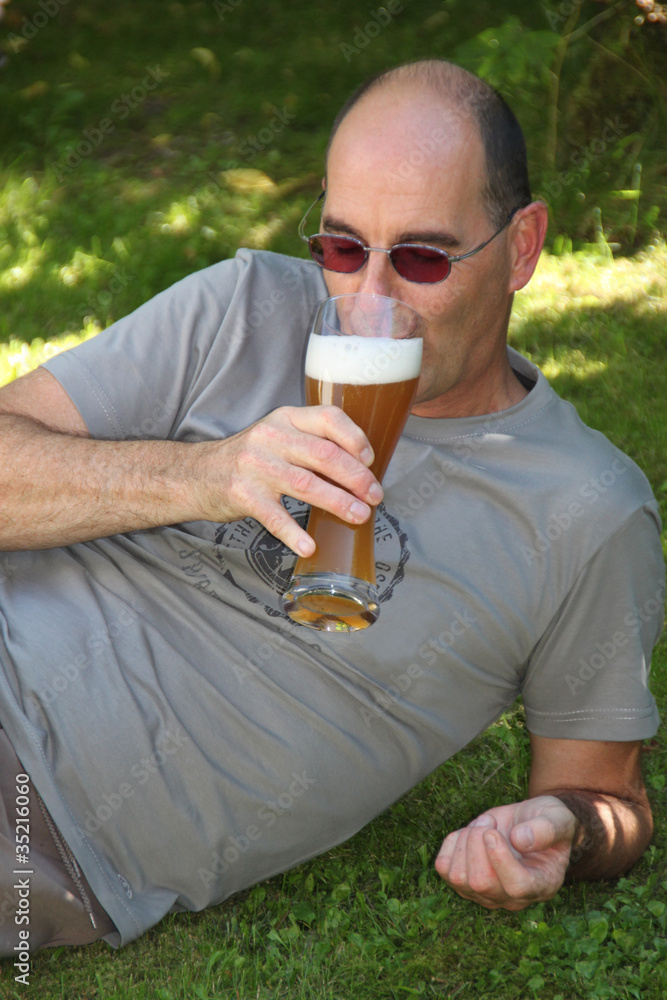 Mann beim Weißbiertrinken im Grünen Mann beim Weißbiertrinken im Grünen