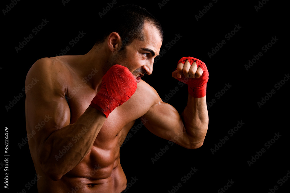 Young Boxer fighter over black background