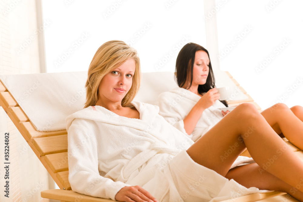 Luxury spa two women relax sitting sun-beds Luxury spa two women relax sitting sun-beds