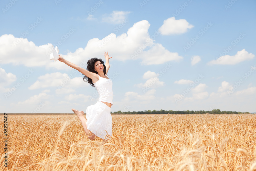 Happy woman jumping in golden wheat Happy woman jumping in golden wheat