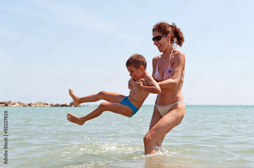 Mother and son playing on the beach.