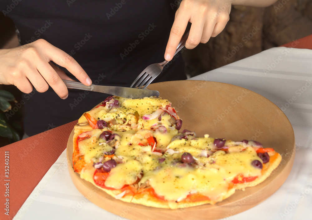 Woman eating vegetarian pizza in a pizzeria