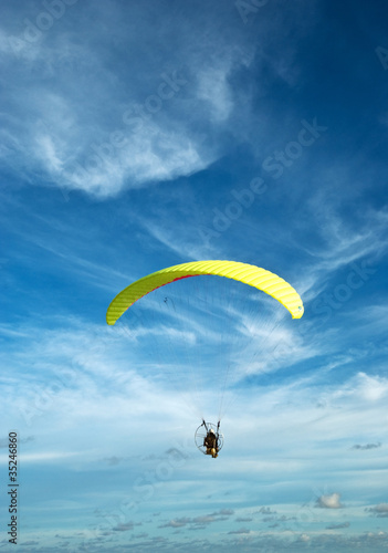 Flying paramotor in the blue sky