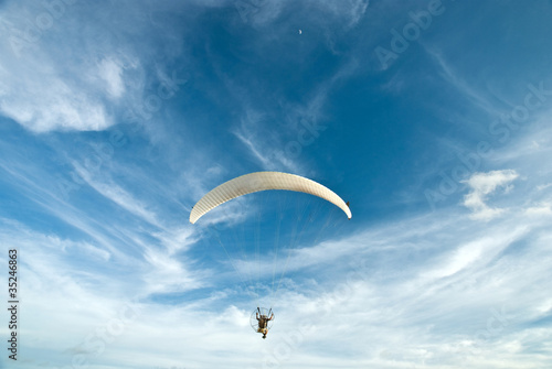 Flying paramotor in the blue sky
