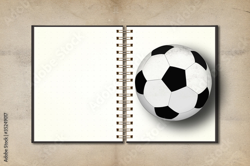 Football and blank notebook on grunge vintage background