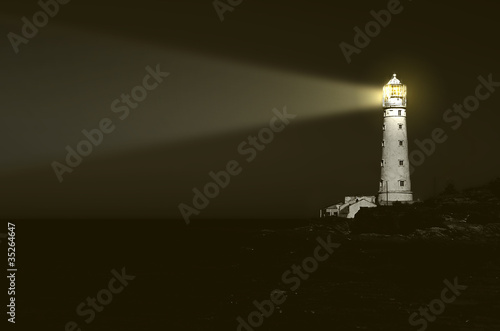 lighthouse at night: beam of light over sea