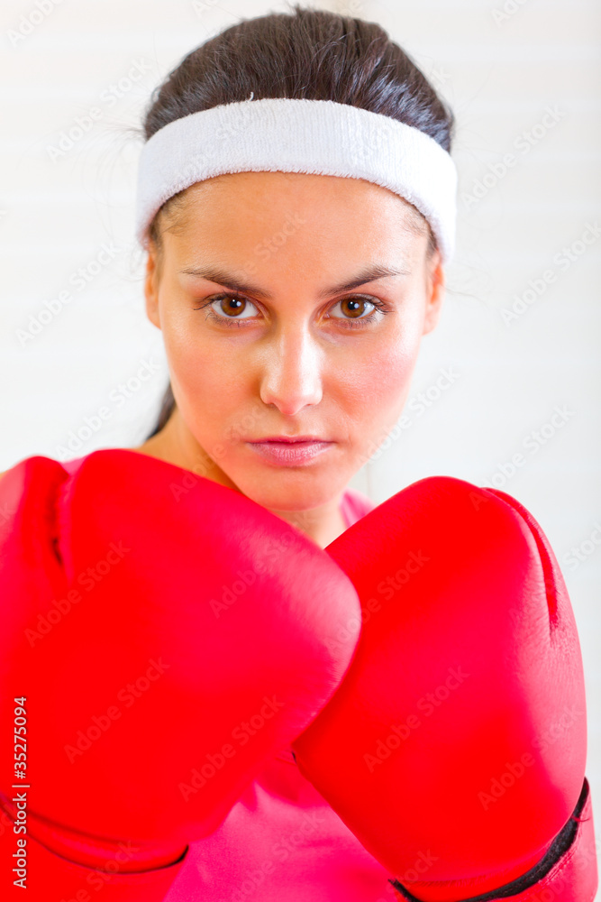 Portrait of concentrated fit girl in boxing gloves Portrait of concentrated fit girl in boxing gloves