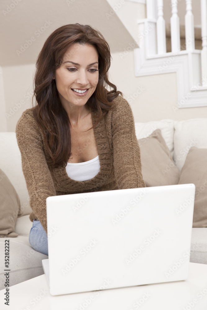 Brunette Woman Using Laptop Computer At Home on Sofa Brunette Woman Using Laptop Computer At Home on Sofa