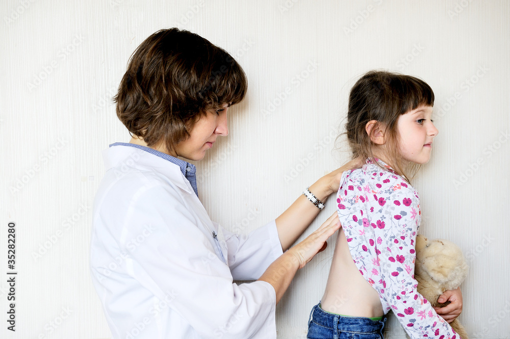Young female doctor examining a little child girl Young female doctor examining a little child girl
