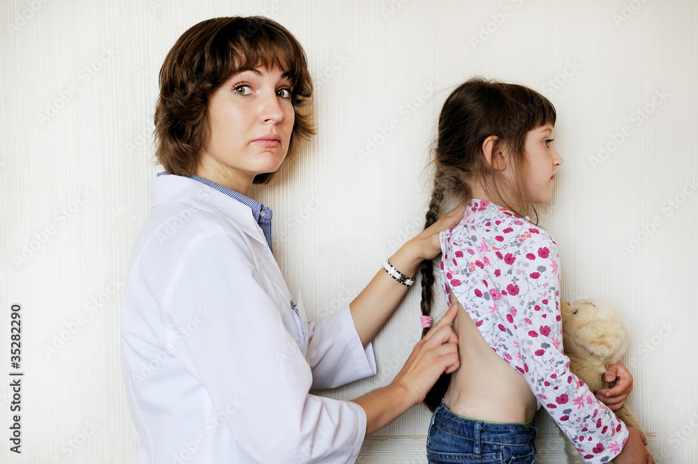 Young female doctor examining a little child girl Young female doctor examining a little child girl
