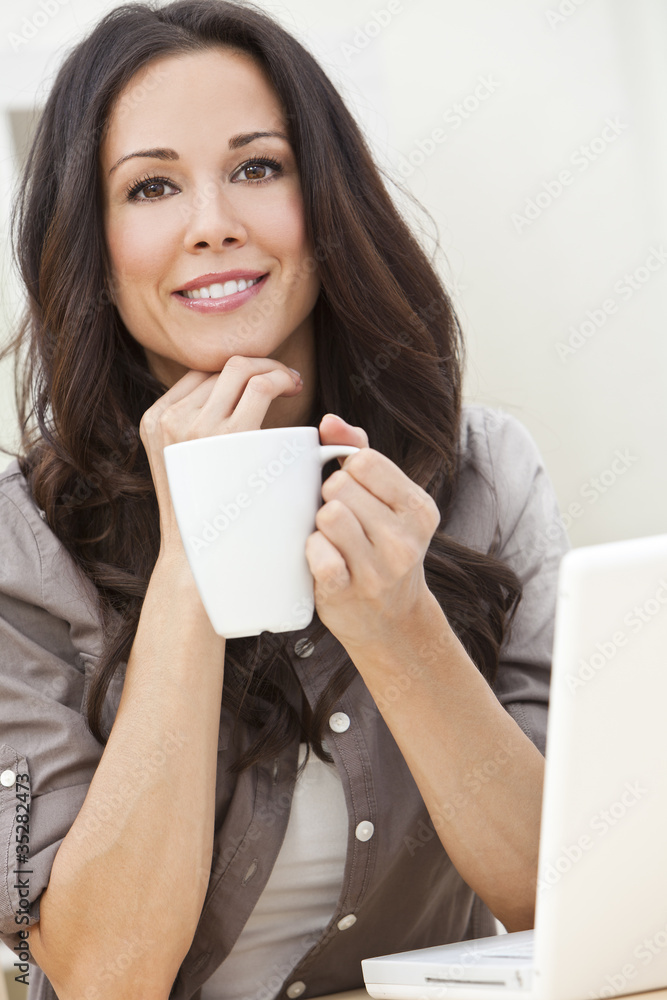 Woman Using Laptop Computer At Home Drinking Tea or Coffee Woman Using Laptop Computer At Home Drinking Tea or Coffee