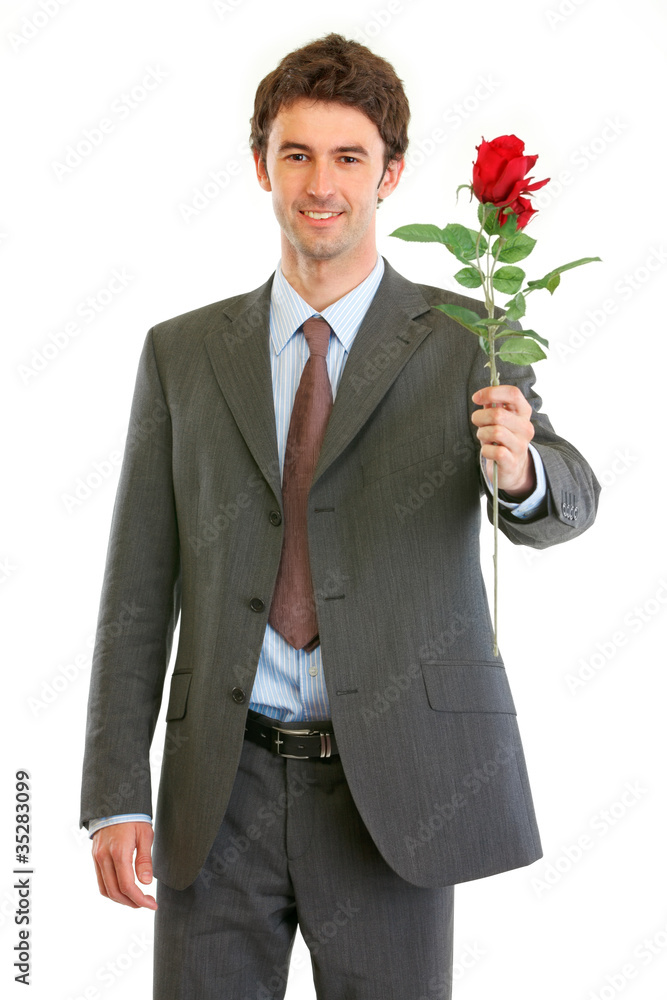Smiling modern businessman with red rose in hand