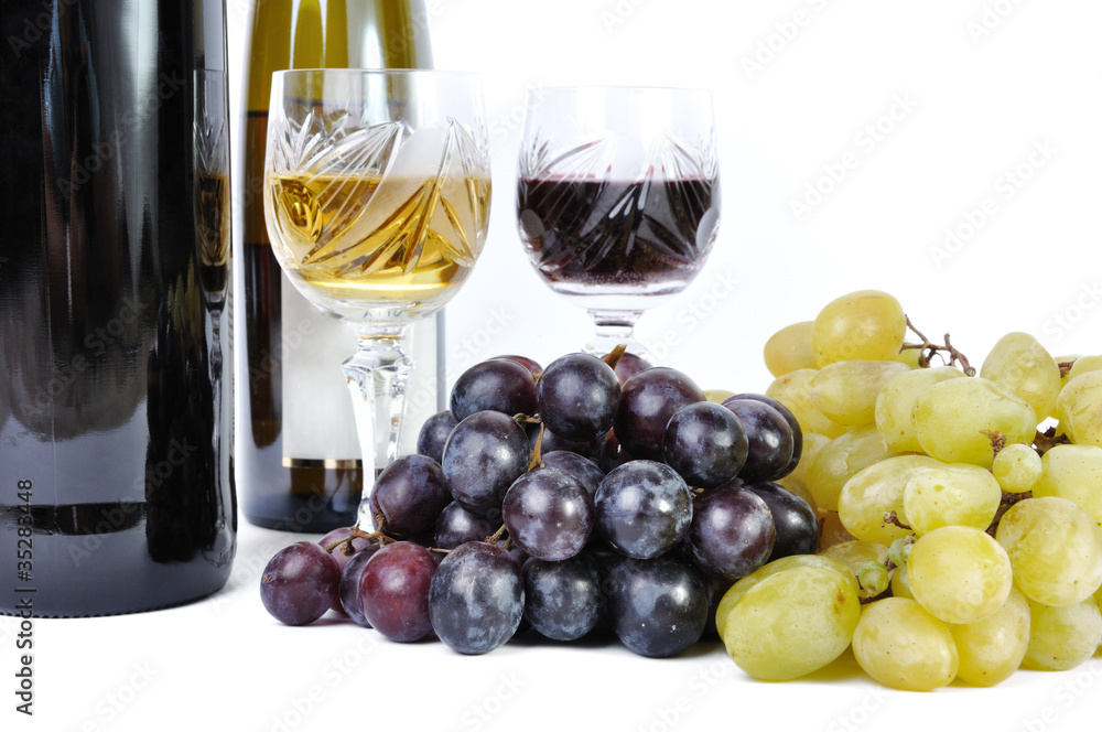 Two bottles of wine with two glasses of wine and grapes