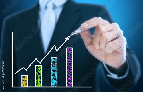 businessman writing rising graph ,blue background