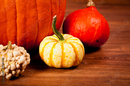 Ripe pumpkin fruits on wooden background photo