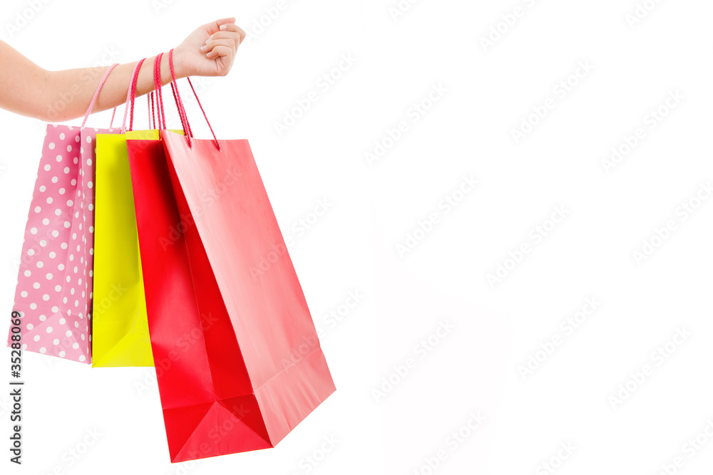 Female hand holding colorful shopping bags, isolated on white