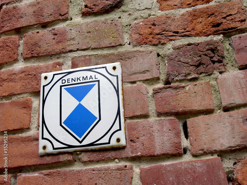 Denkmal Schild an Backsteinmauer