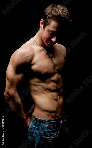 Obraz na plátně Muscle sexy naked young man posing in the dark