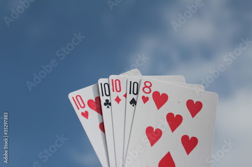 Poker hand - Four of a kind, with sky background
