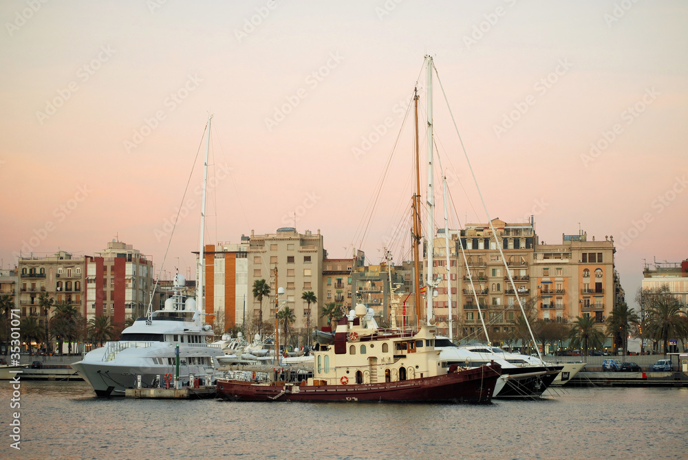 yachts and the ships in evening port Port Vell in Barcelona, Spa