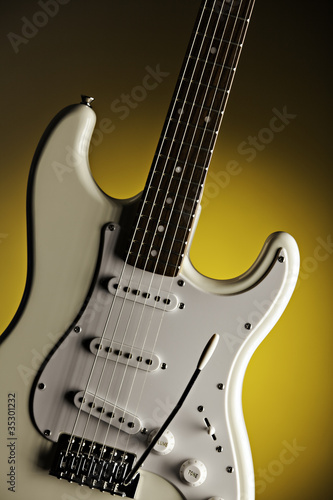 White Guitar Isolated On Yellow Spotlight