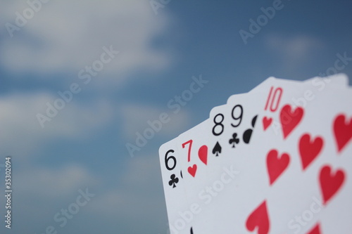 Poker hand - Straight Flush, with sky background