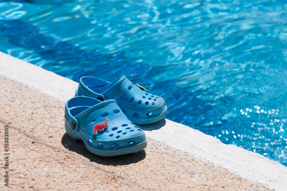 Chanclas azules al borde de piscina Stock Photo | Adobe Stock