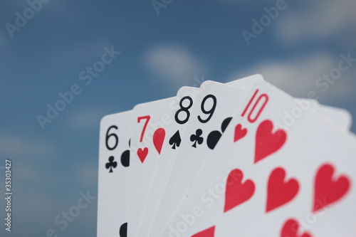 Poker playing cards with sky background - Straight Flush hand