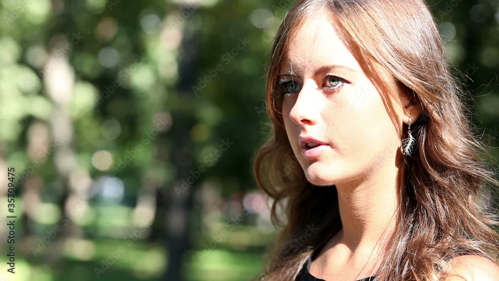 girl paints lips in park and looks in a mirror girl paints lips in park and looks in a mirror