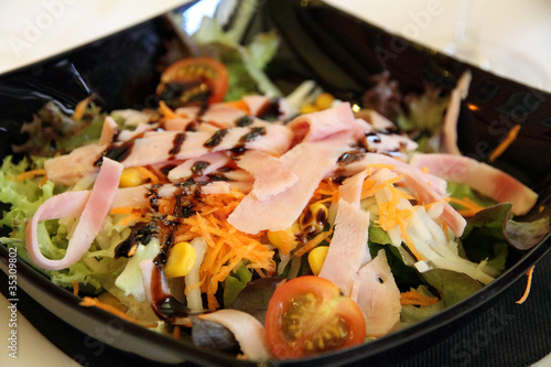 Slika na platnu Salad on a black plate