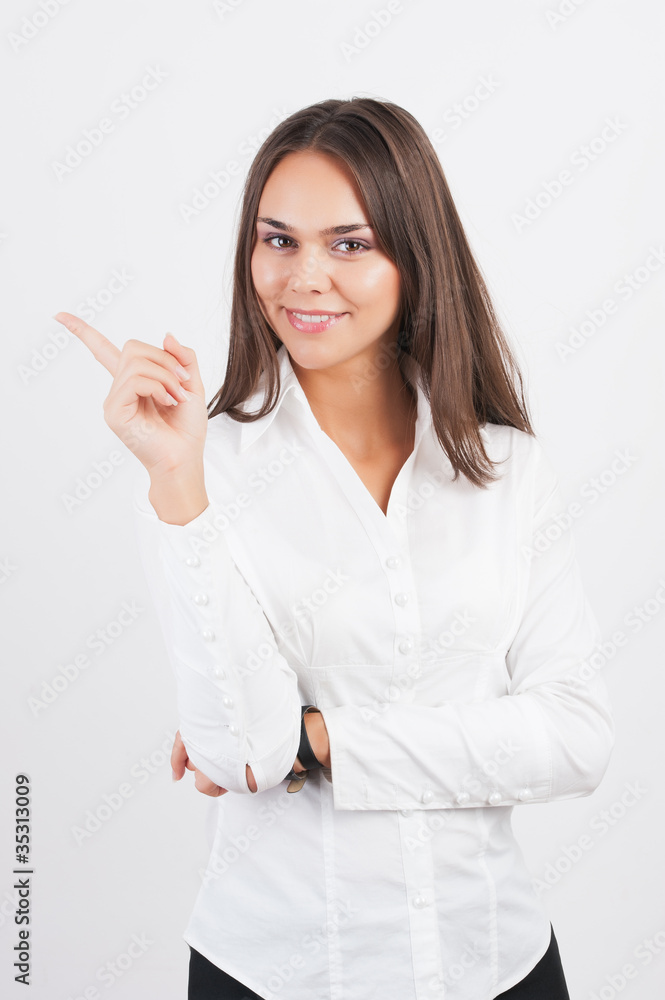Happy smiling young business woman showing blank area for sign o Happy smiling young business woman showing blank area for sign o