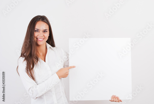 Happy smiling young business woman showing blank signboard