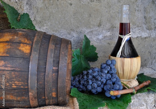 Fiasco di vino con grappolo d'uva