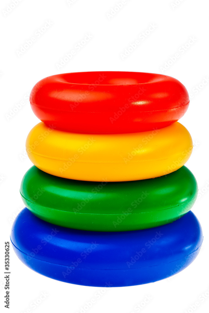 Colorful round plastic toys stacked over white background. Colorful round plastic toys stacked over white background.