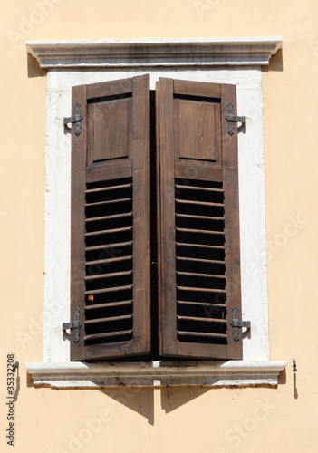 brown wooden retro shutters in window, Italy