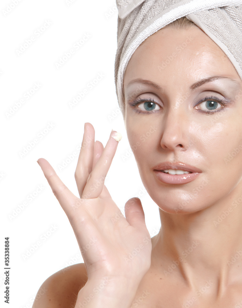 The beautiful young woman with a cosmetic cream.. The beautiful young woman with a cosmetic cream..