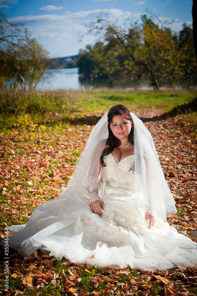 Fototapeta premium Beautiful bride posing in autumn park
