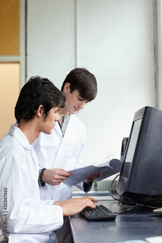 Male scientists using a monitor Male scientists using a monitor