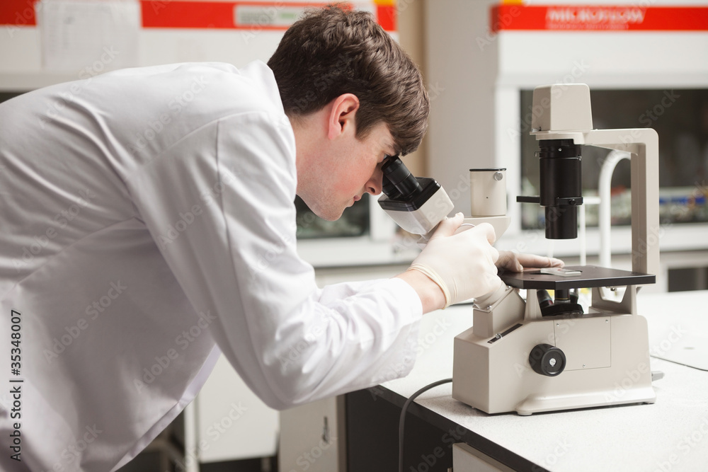 Young science student looking in a microscope