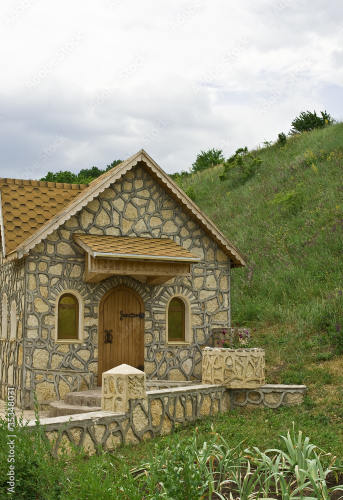 Small one-story house, lined with natural stone. Small one-story house, lined with natural stone.