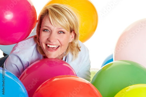 Frau inmitten bunter Ballons
