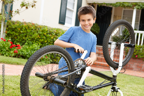 boy fixing bike in garden