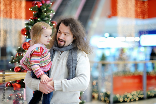 Young father and his toddler girl in shopping mall on Christmas