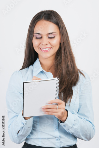 Happy smiling young businesswoman with clipboard writing,