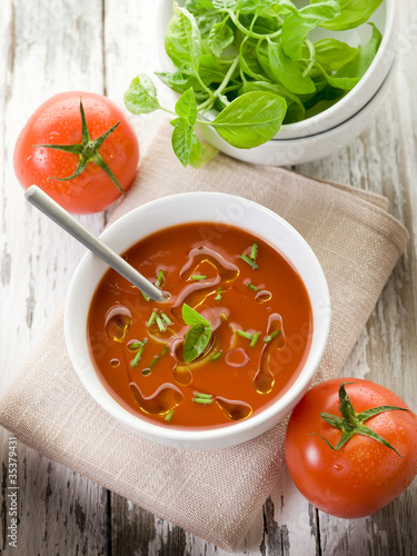 tomato soup with basil leaf on bowl