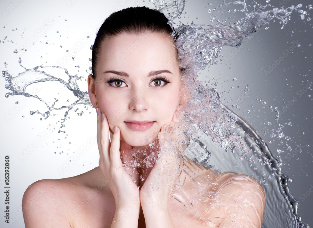Naklejka premium Splashes of water on the face of beautiful sexy woman
