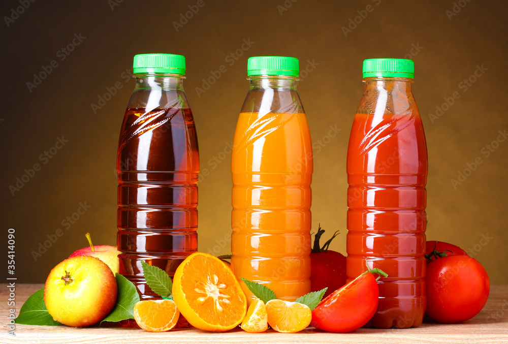 Different juices and fruits on wooden table on brown background Different juices and fruits on wooden table on brown background