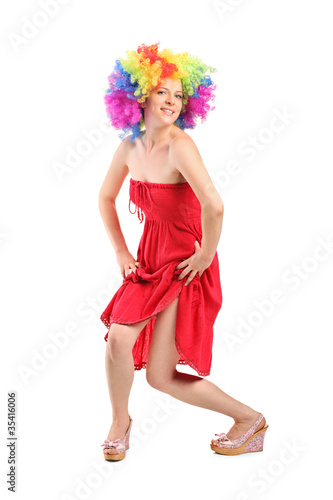 Woman in rainbow clown wig with freckles posing